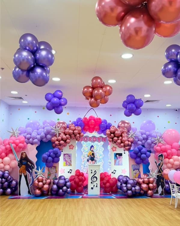 A KPop Demon Hunters party setup with purple and rose chrome balloons