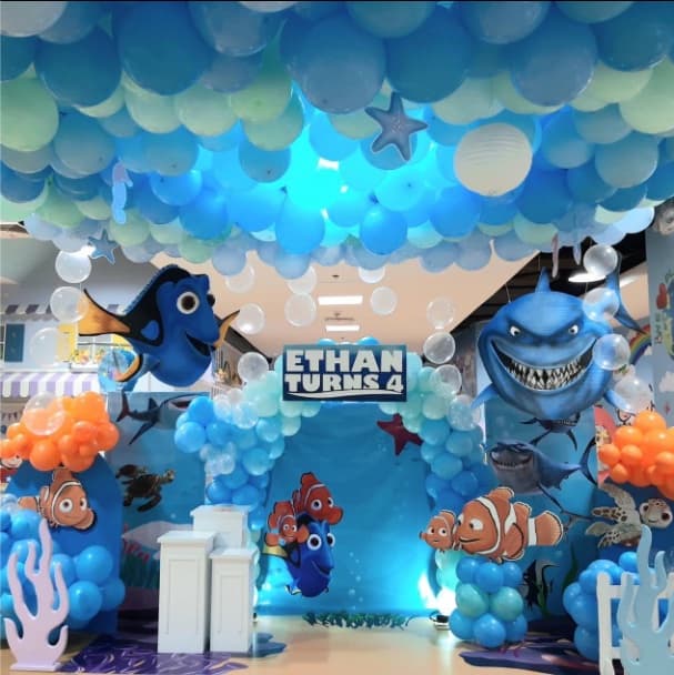 A Finding Nemo party setup with a blue balloon ceiling and reef cut-outs