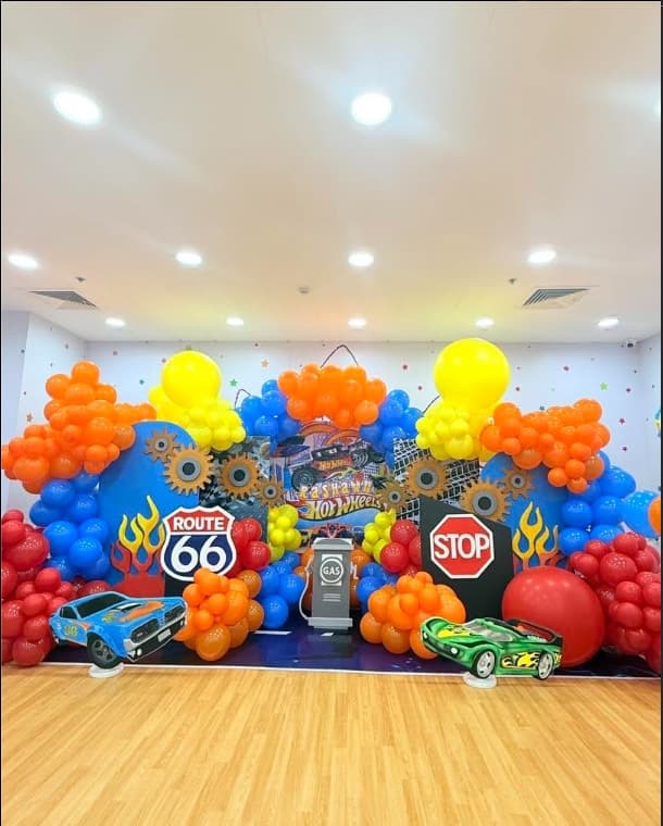 A Hot Wheels party setup with flame decals, road signs and race car cut-outs