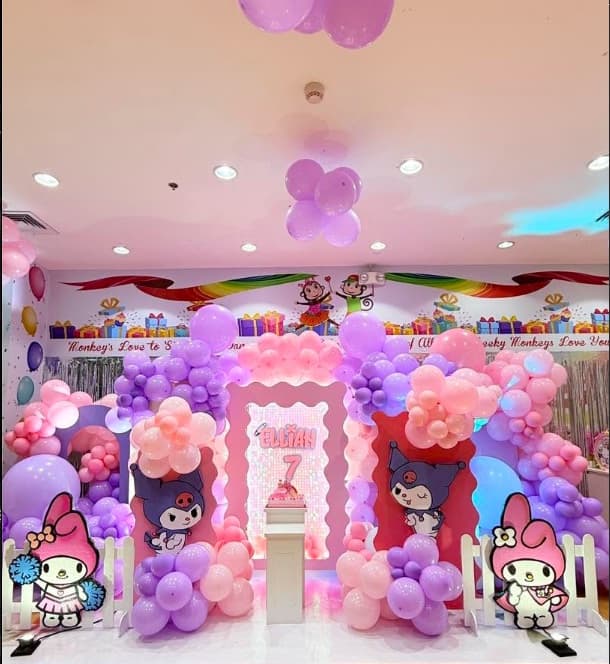 A Kuromi party setup with pink and purple balloons and Sanrio cut-outs