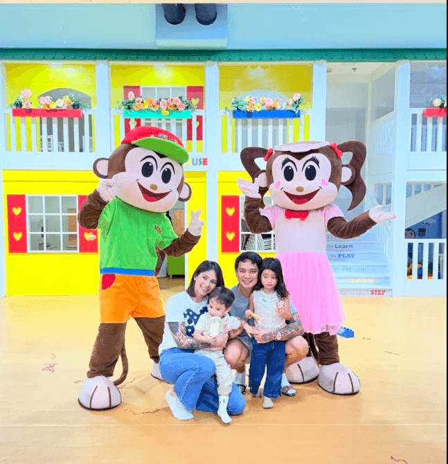 A family posing with the Mimi and Juju mascots