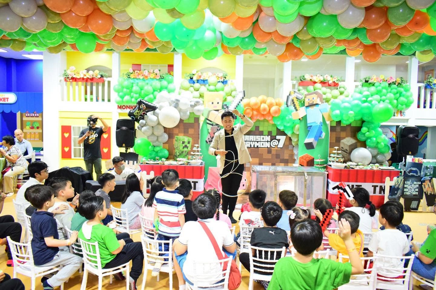 A decorated party hall with children watching the host
