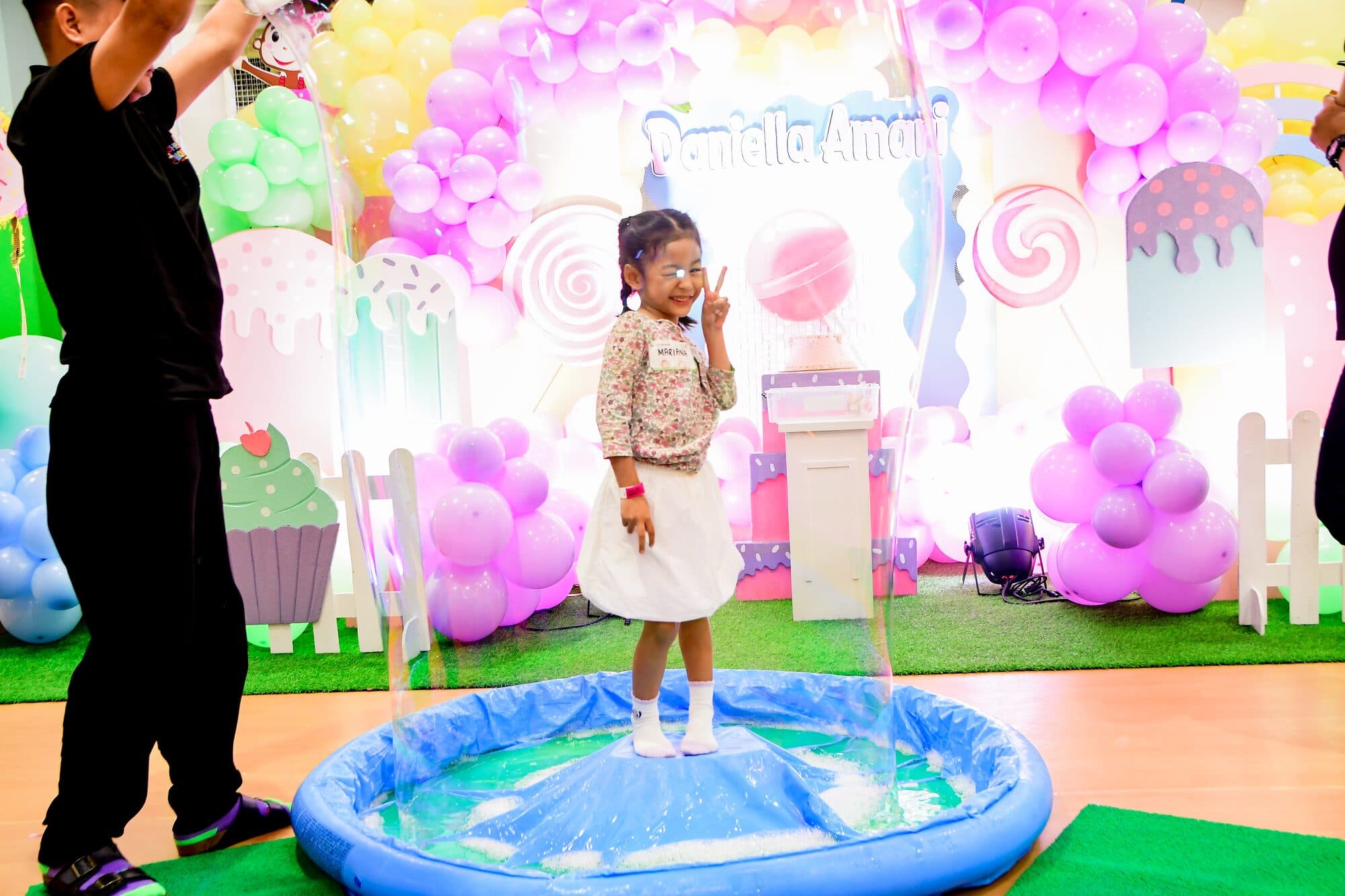 A child standing inside a giant soap bubble at a science show